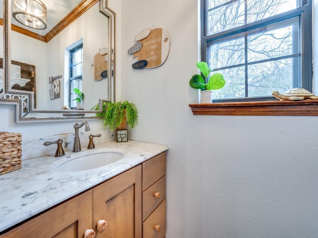 41 White Oak Road Gainesville, TX 76240 - Photo 21 of 38 a bathroom with a granite countertop sink a mirror and a window