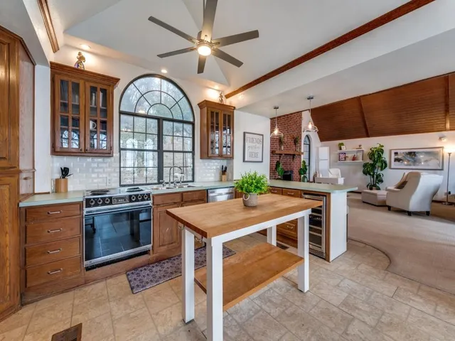 a kitchen with stainless steel appliances granite countertop a stove refrigerator and a sink