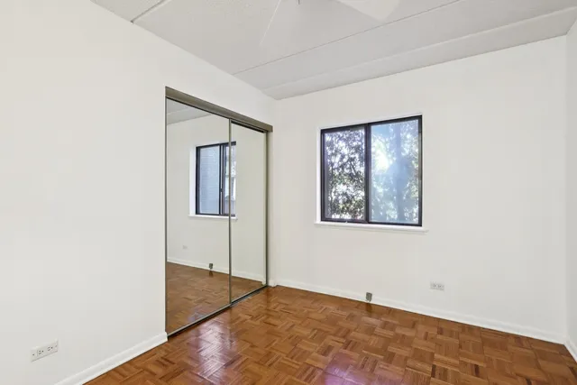 a view of an empty room with closet and a window