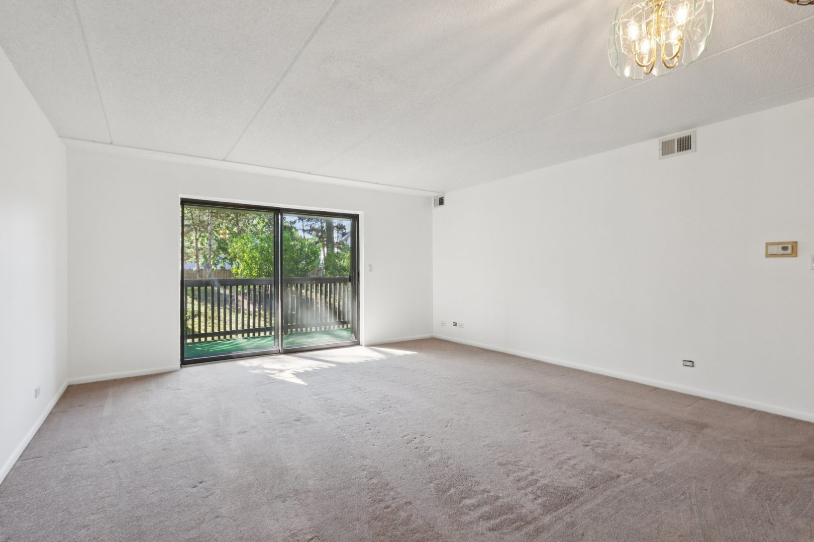 920 Vose Drive, Unit 106 Gurnee, IL 60031 - Photo 9 of 39 a view of empty room with floor to ceiling window