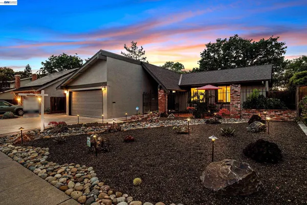 a view of a house with backyard and sitting area
