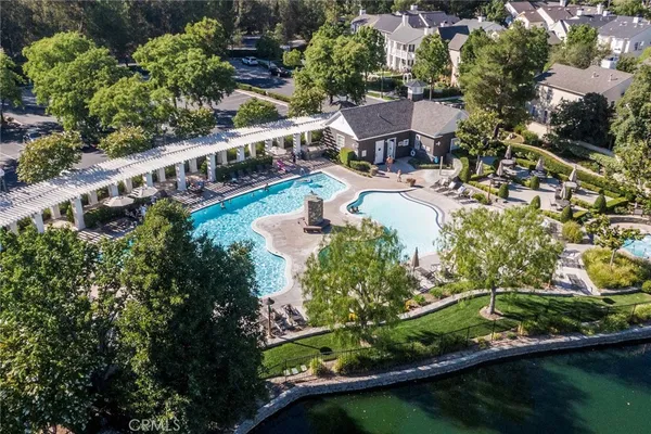 an aerial view of a house with swimming pool a yard and a patio