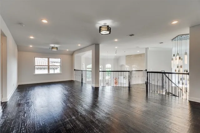 a view of empty room with wooden floor and windows