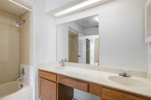 a bathroom with a tub sink and mirror