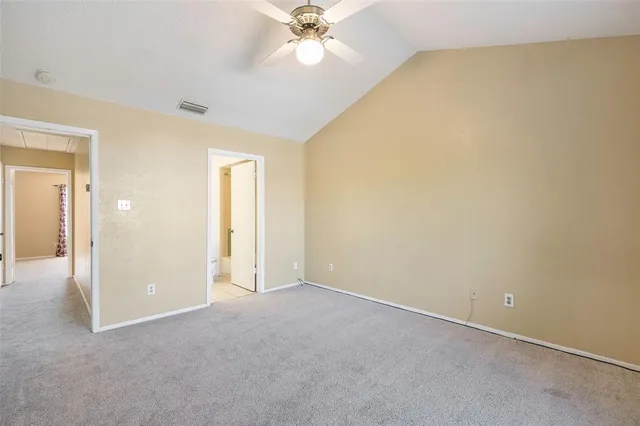 an empty room with a ceiling fan and a window