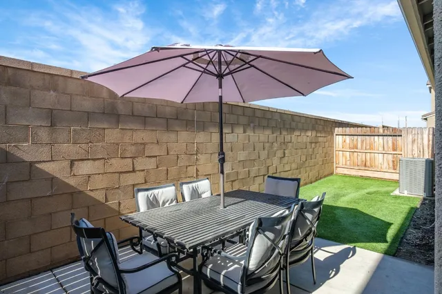 a patio with a table and chairs under an umbrella