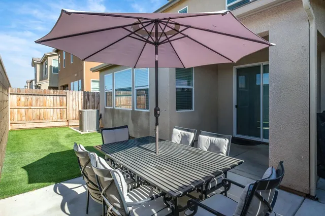 a patio with a table and chairs under an umbrella