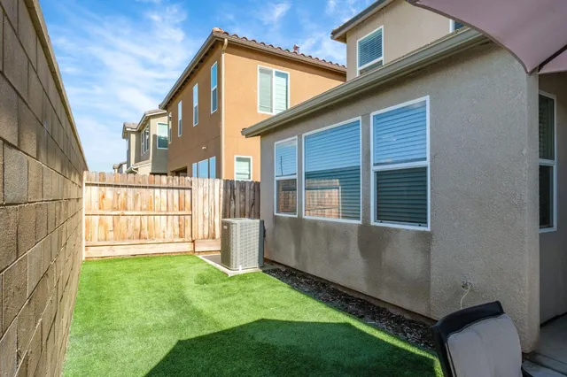a view of backyard with a large tree and wooden fence