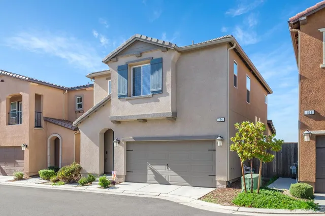 a front view of a house with a yard garage and outdoor seating