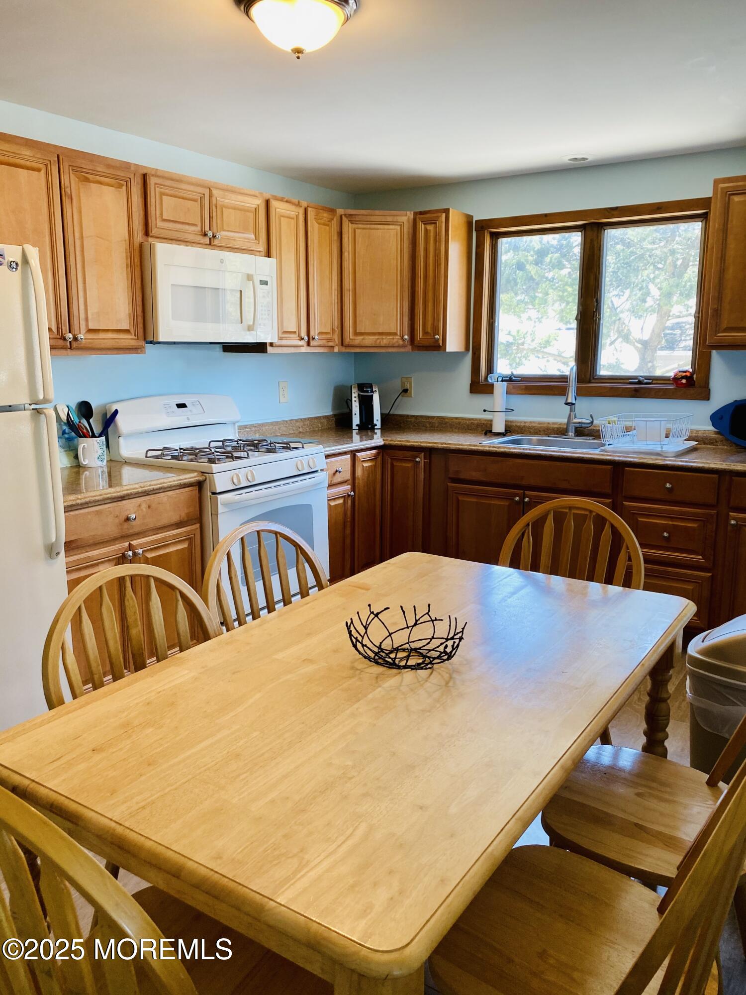 104 5th Avenue, Unit DOWN Seaside Heights, NJ 08751 - Photo 4 of 10 a kitchen with stainless steel appliances granite countertop a stove a sink a dining table and chairs