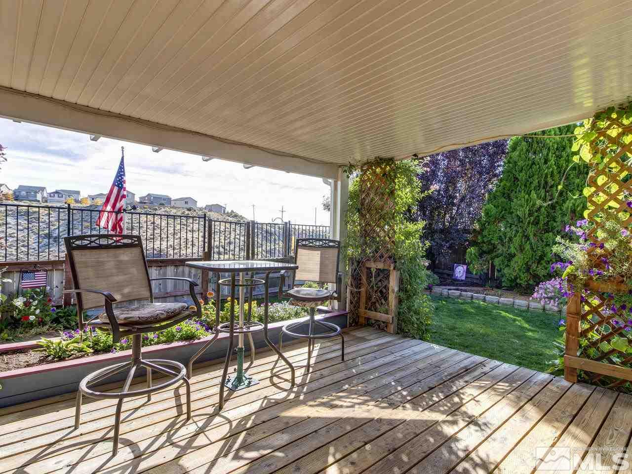 1040 Backer Way Reno, NV 89523 - Photo 21 of 25 a view of a patio with a dining table and chairs with wooden floor and fence