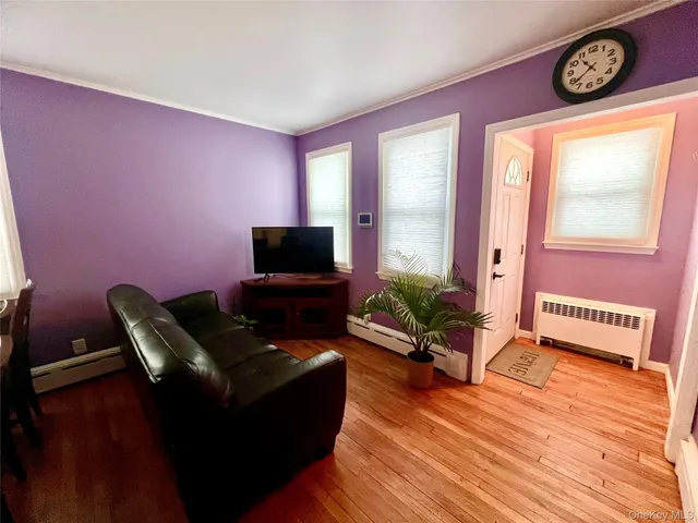 a living room with furniture wooden floor and a flat screen tv