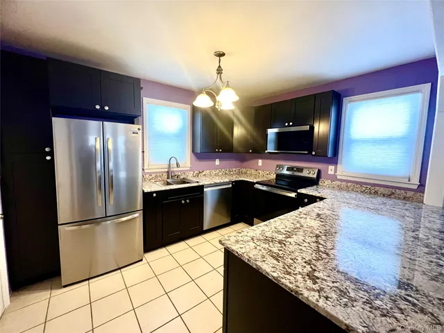 a kitchen with granite countertop a refrigerator a stove and a sink