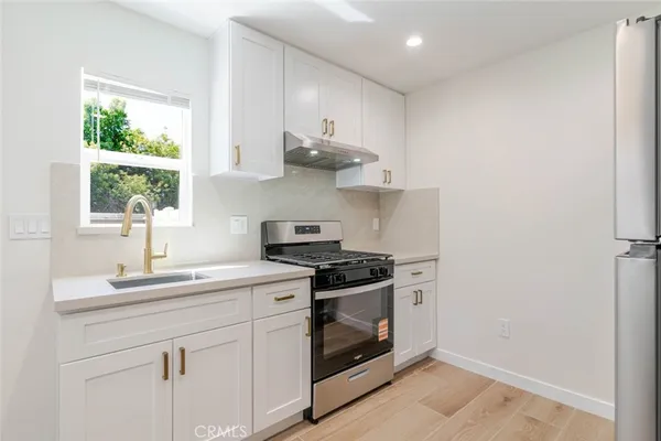 a kitchen with stainless steel appliances white cabinets and a sink