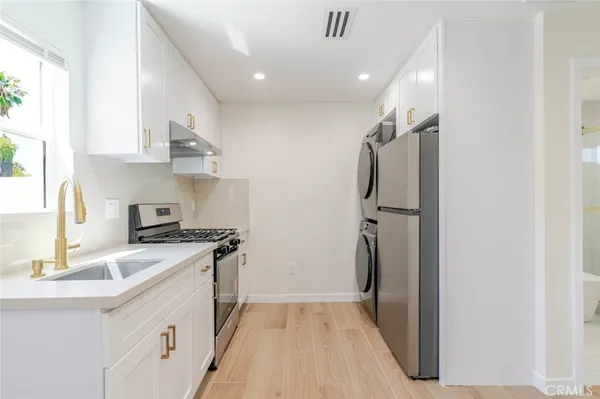 a kitchen with stainless steel appliances granite countertop a refrigerator and a sink