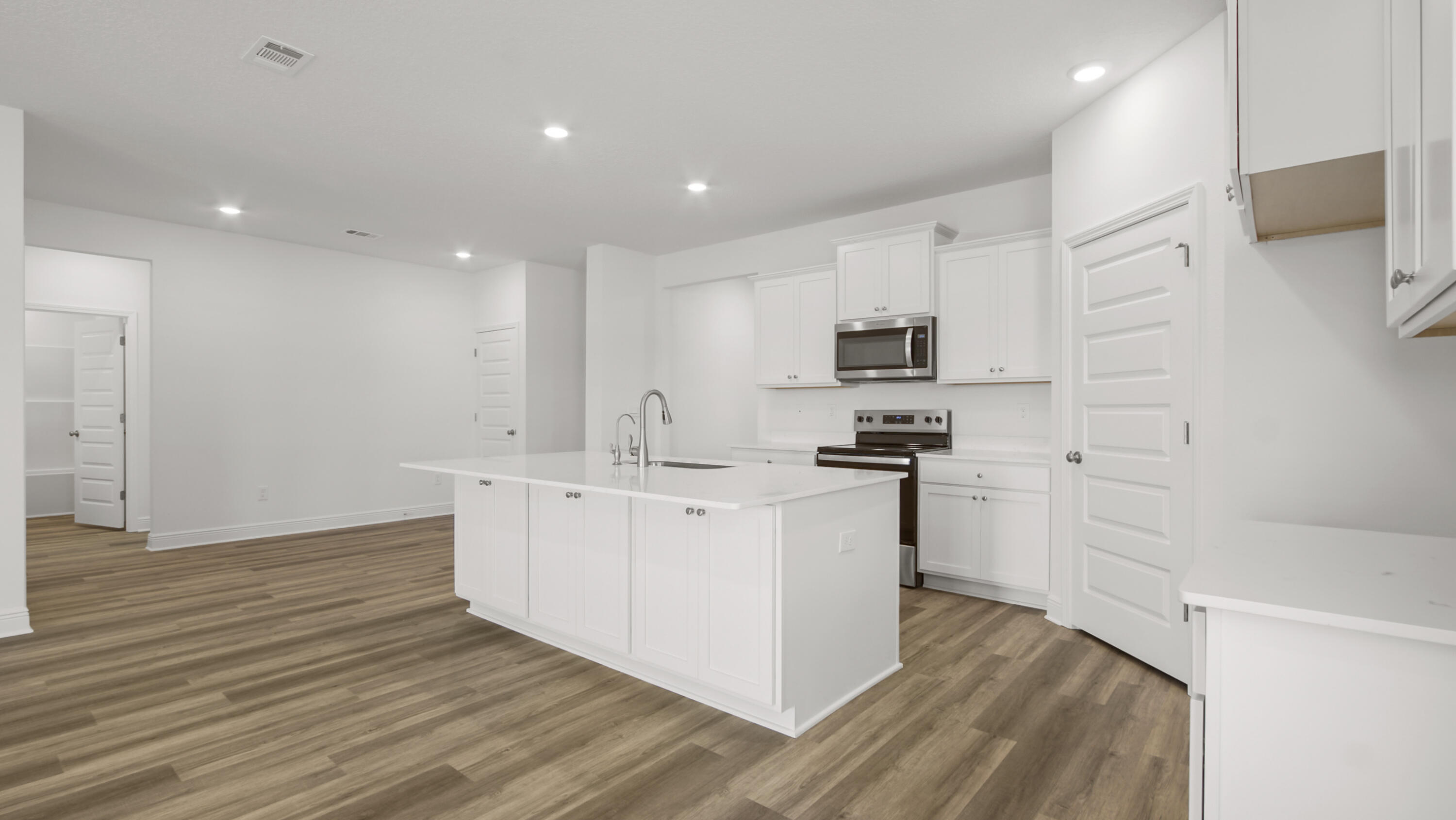 70 Gray Owl Drive Freeport, FL 32439 - Photo 7 of 20 a kitchen with cabinets stainless steel appliances and wooden floor