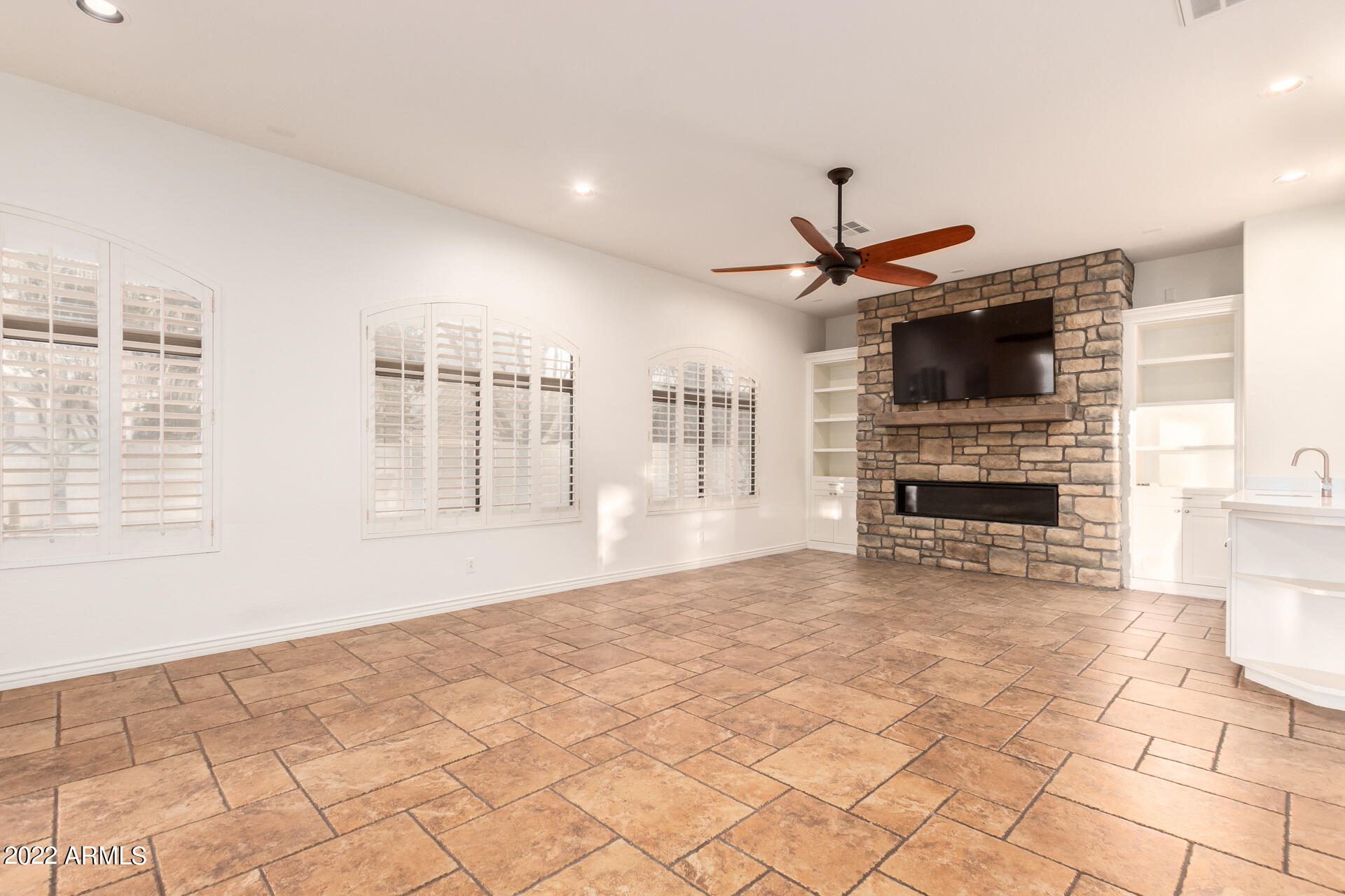 4584 East Reins Road Gilbert, AZ 85297 - Photo 12 of 80 a living room with couches a flat screen tv and kitchen view