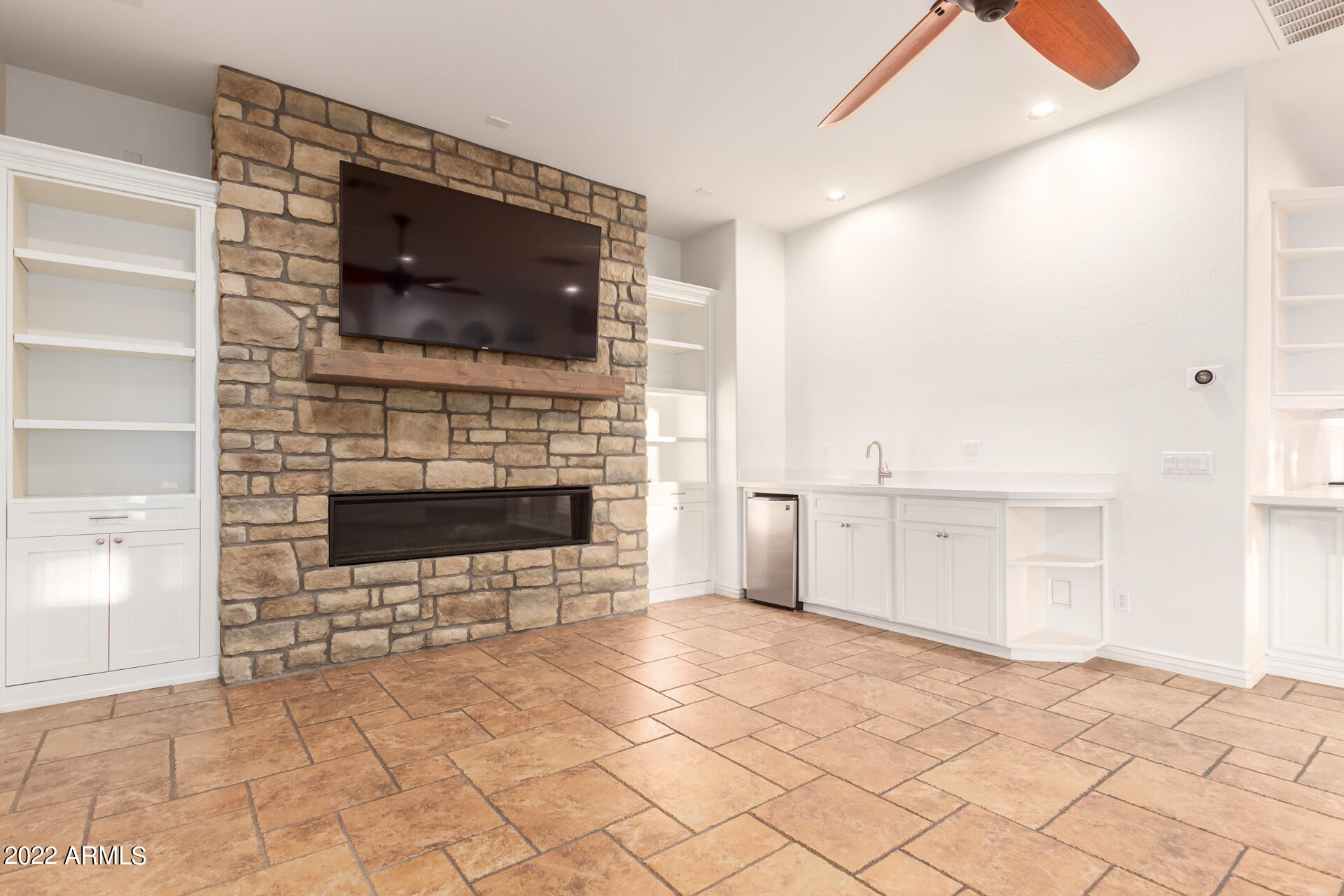4584 East Reins Road Gilbert, AZ 85297 - Photo 13 of 80 a living room with a fireplace and a flat screen tv