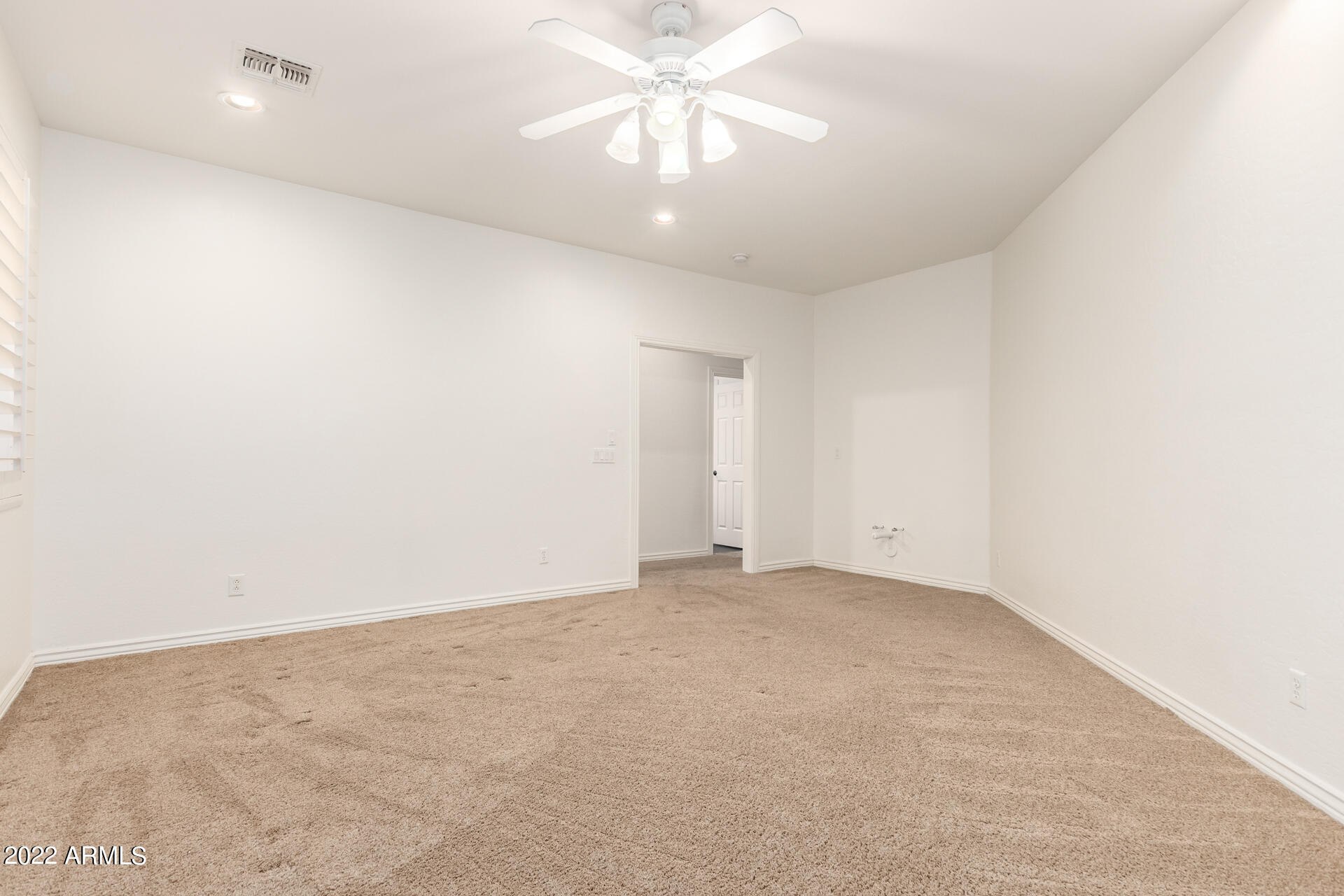 4584 East Reins Road Gilbert, AZ 85297 - Photo 22 of 80 an empty room with a chandelier fan and windows