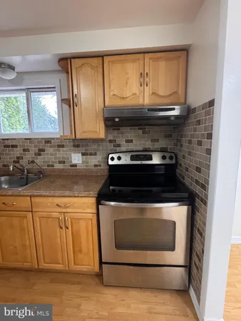 a stove top oven sitting inside of a kitchen