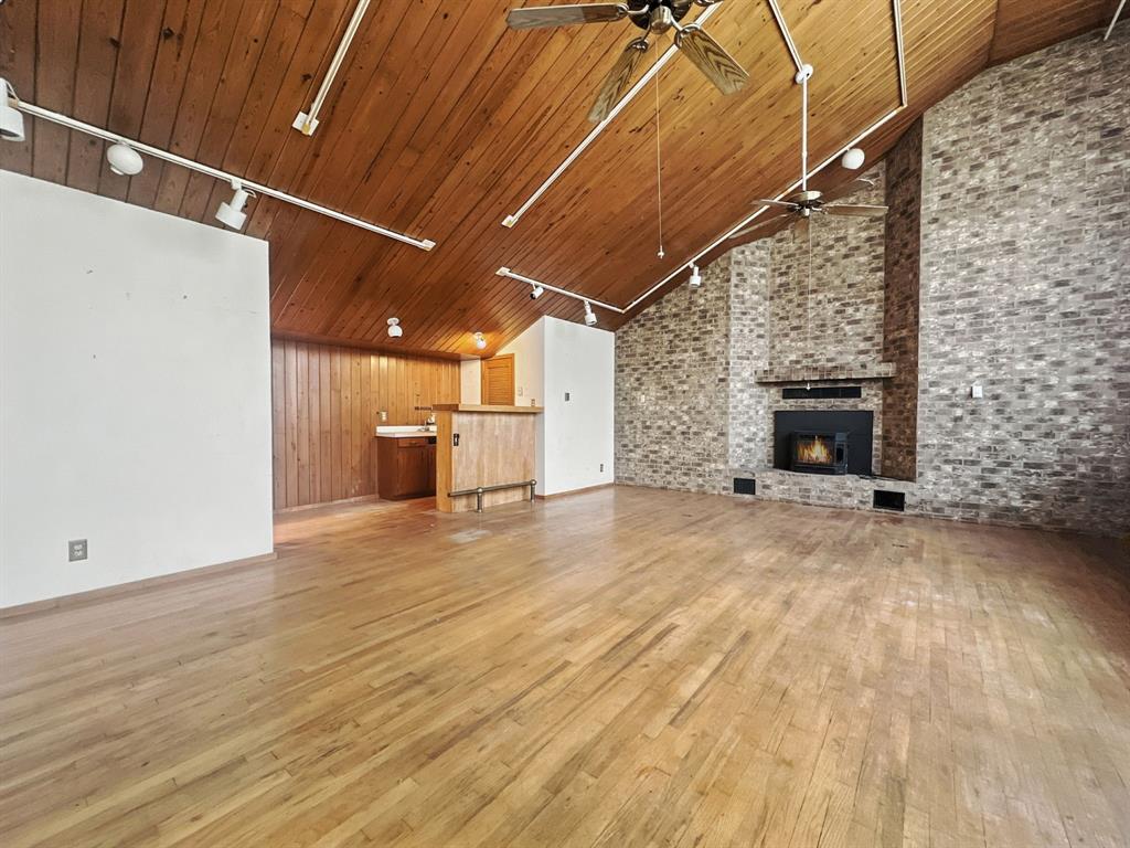 601 East Henry Street Hamilton, TX 76531 - Photo 17 of 40 a view of empty room with wooden floor and fireplace