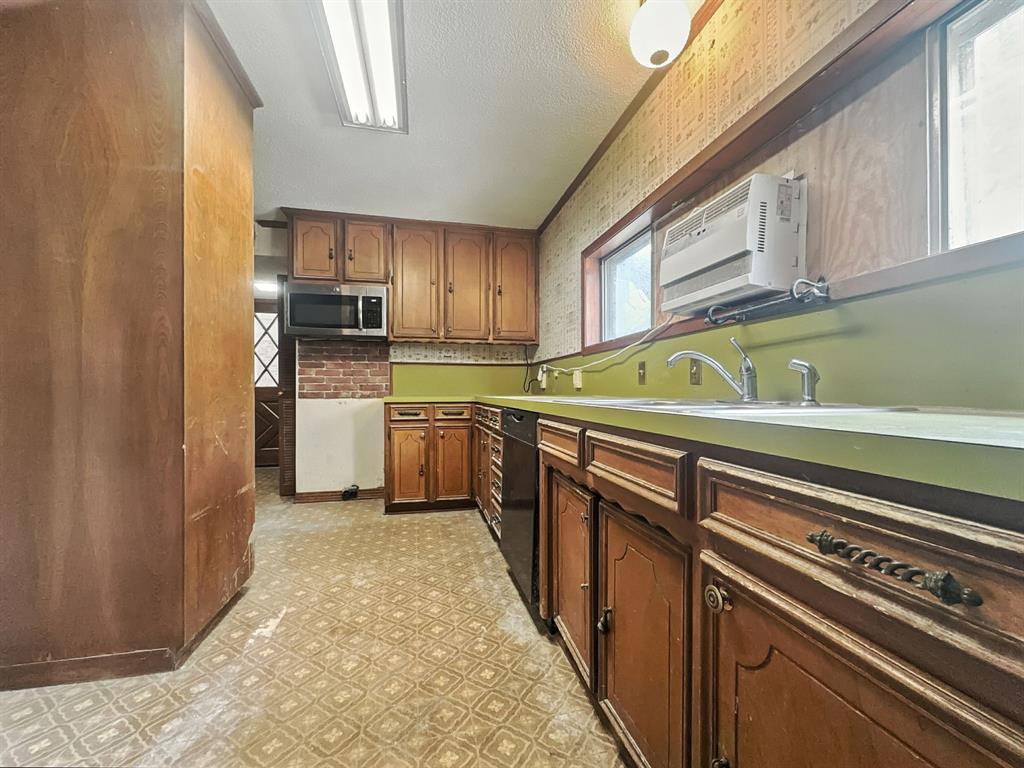601 East Henry Street Hamilton, TX 76531 - Photo 24 of 40 a kitchen with stainless steel appliances a sink dishwasher stove refrigerator and cabinets