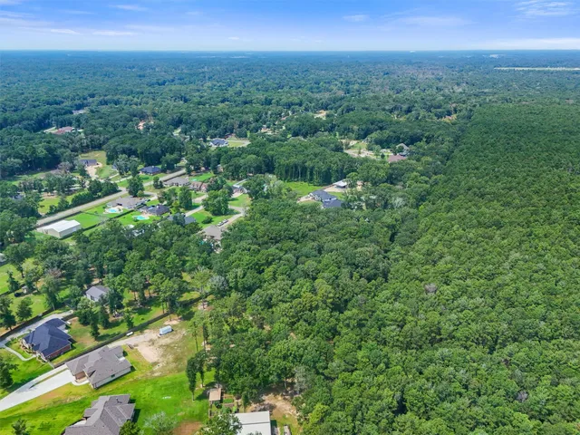 an aerial view of residential house with outdoor space and trees all around