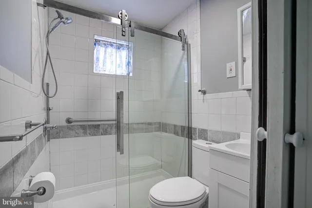a bathroom with a granite countertop bathtub shower sink and toilet