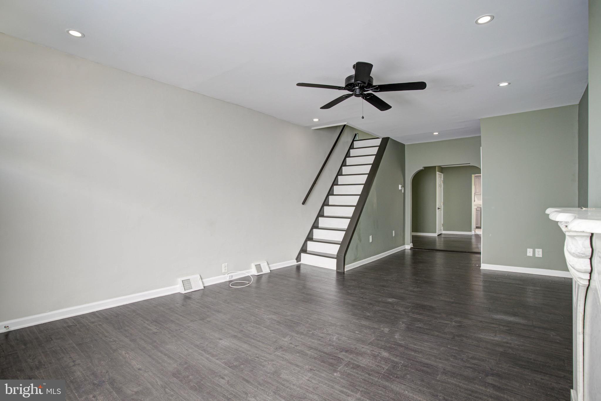 2331 East Hazzard Street Philadelphia, PA 19125 - Photo 14 of 24 a view of an empty room with wooden floor stairs and a ceiling fan