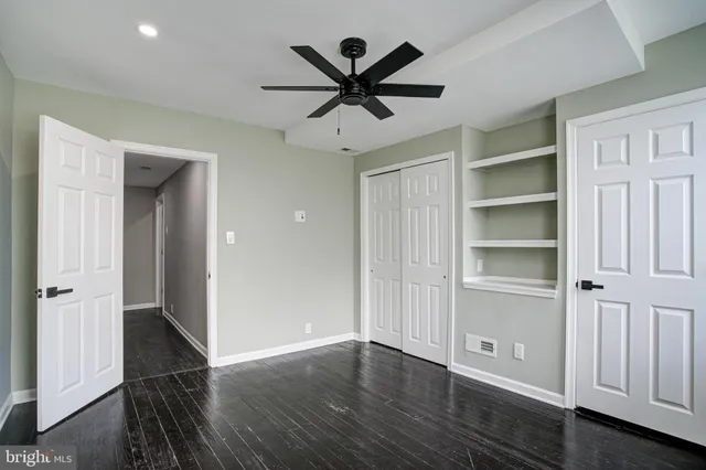 wooden floor with ceiling fan and window