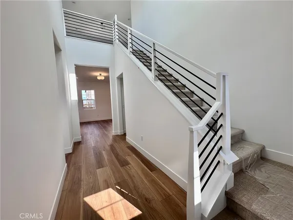 a view of entryway and hall with wooden floor