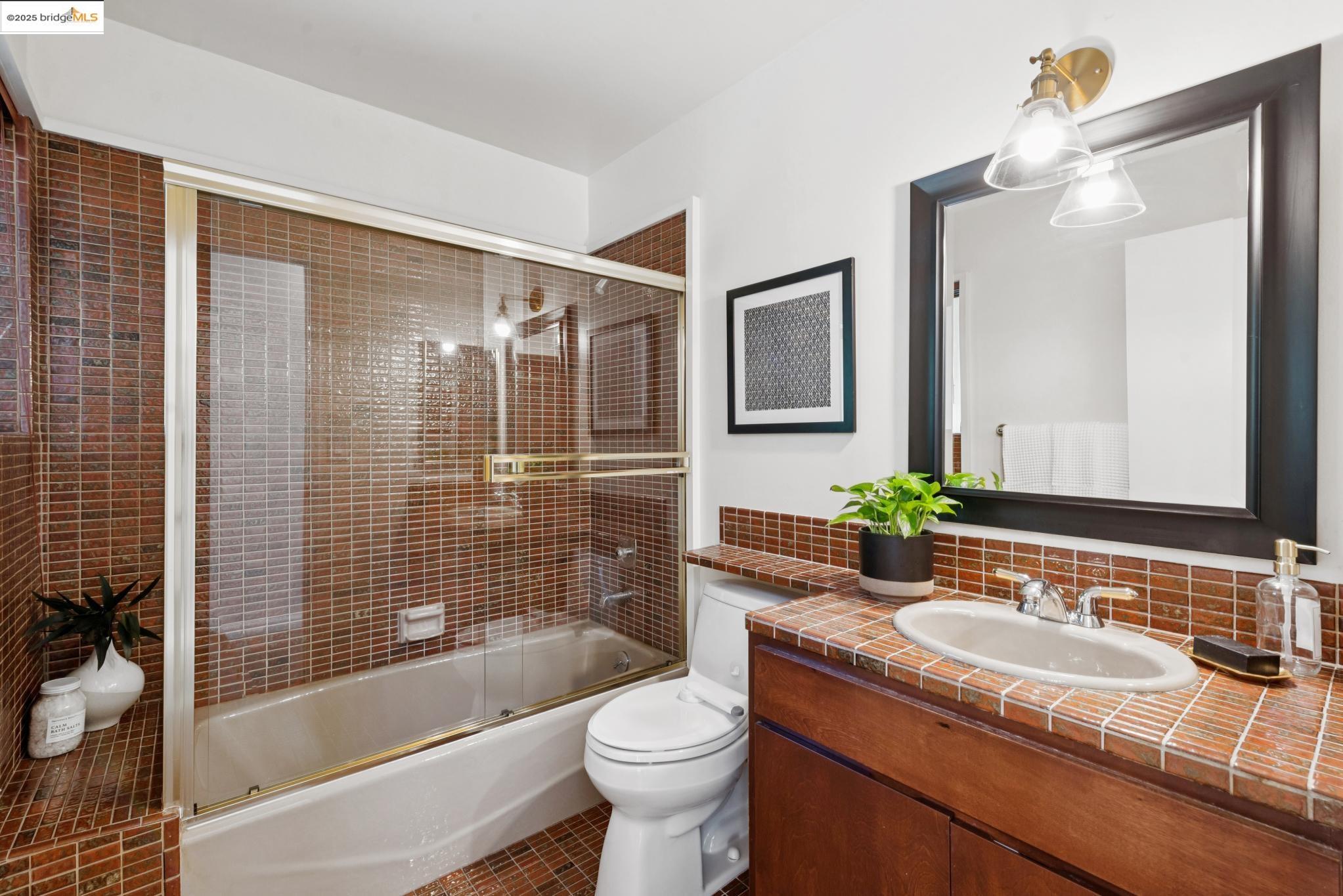 2861 Chelsea Drive Oakland, CA 94611 - Photo 27 of 56 a bathroom with a granite countertop sink toilet mirror and shower