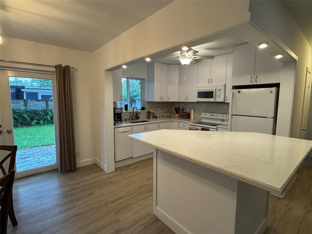 718 Northeast 5th Avenue Pompano Beach, FL 33060 - Photo 3 of 32 a kitchen with kitchen island a sink stainless steel appliances and refrigerator
