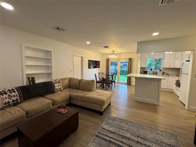 a living room with furniture and view of kitchen