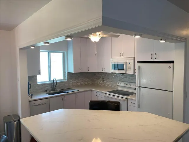 a kitchen with a sink a refrigerator and cabinets
