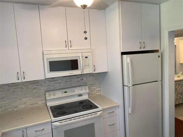 a kitchen with refrigerator a stove a sink and cabinets