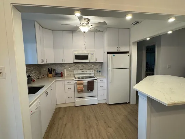 a kitchen with white cabinets and white appliances