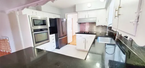 a kitchen with stainless steel appliances a refrigerator a sink a stove and cabinets