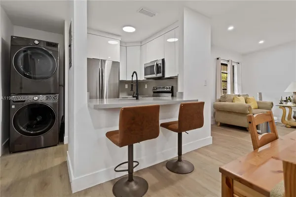 a bed sitting in a bedroom next to a window with chair and a flat screen tv