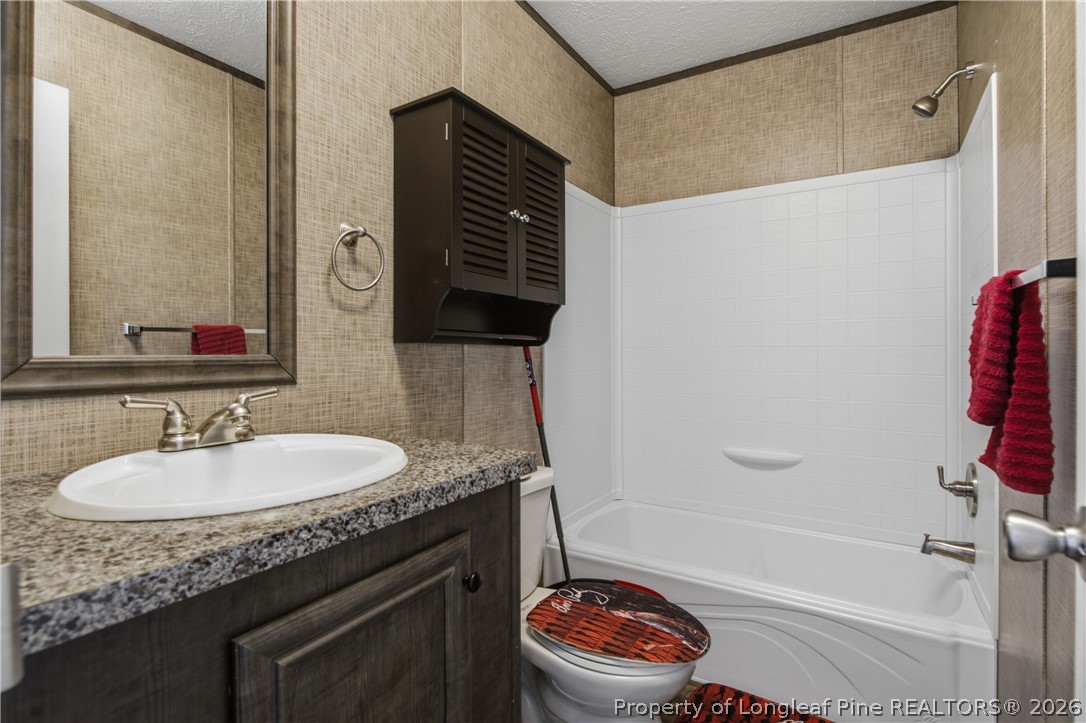 8637 Durant Nixon Road Linden, NC 28356 - Photo 13 of 36 a bathroom with a granite countertop sink toilet and shower