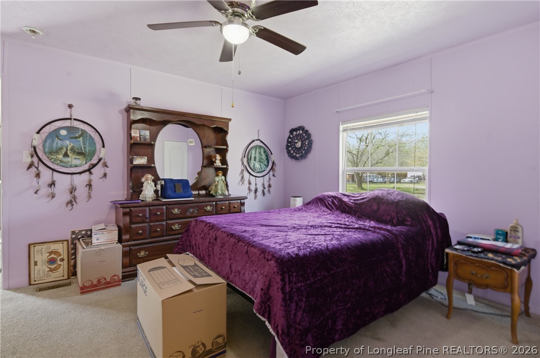 8637 Durant Nixon Road Linden, NC 28356 - Photo 9 of 36 a bed room with a bed and a chandelier