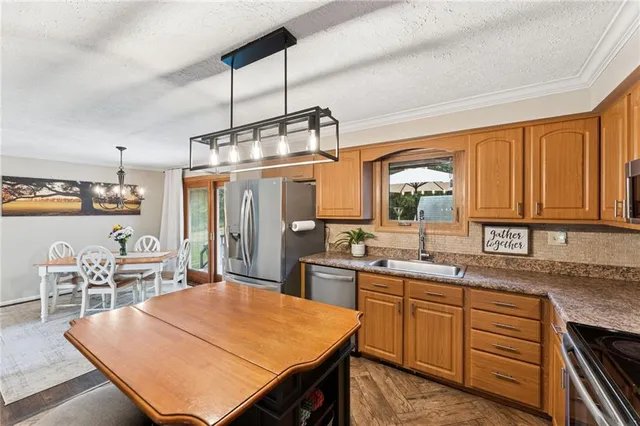 a kitchen with a stove a sink a kitchen island with chairs and wooden cabinets