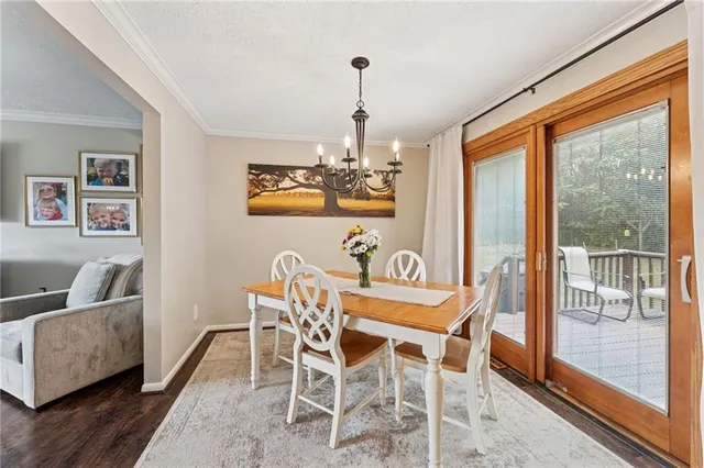 a dining room with furniture a chandelier and wooden floor