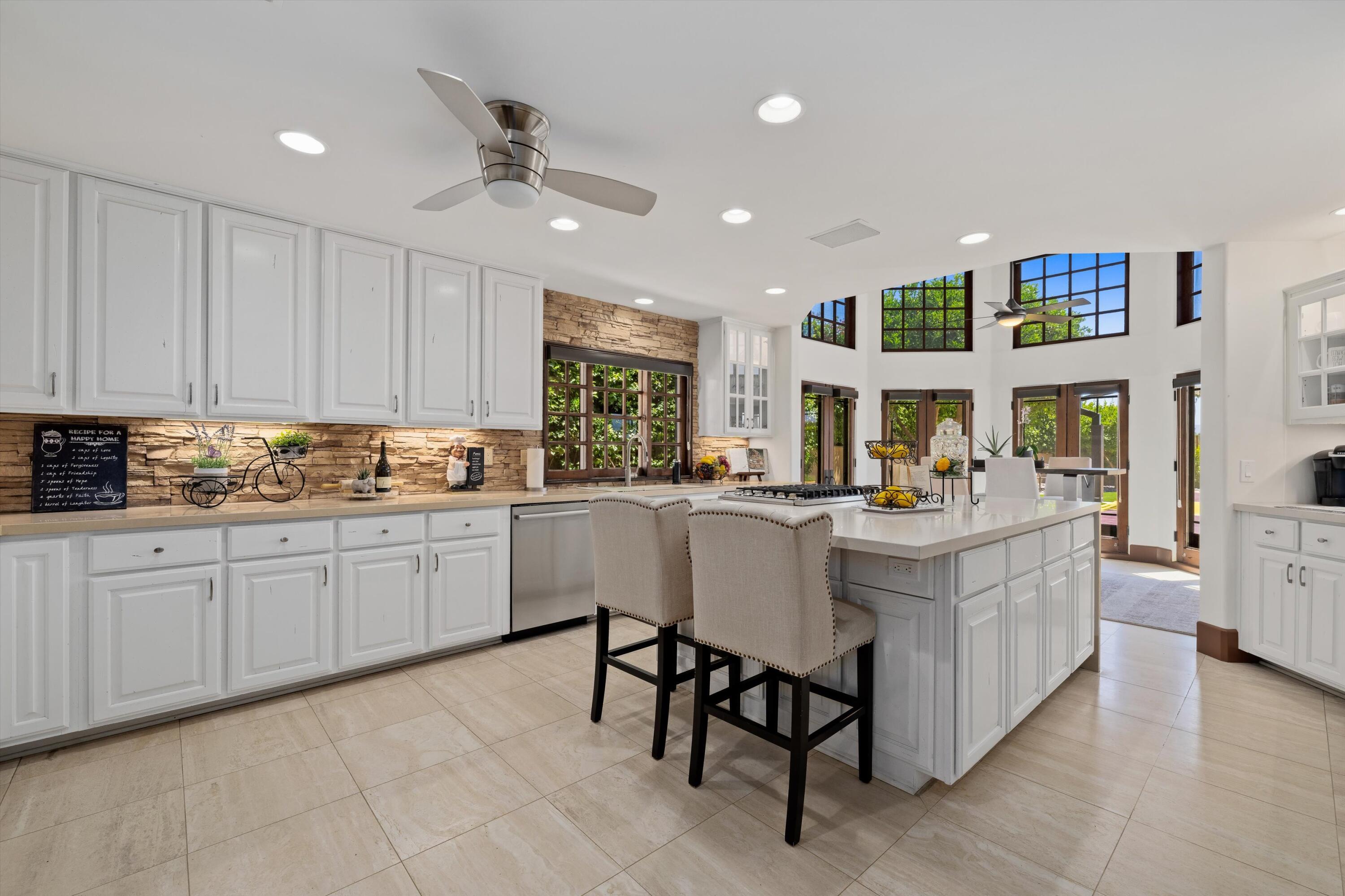 43190 Moore Circle Bermuda Dunes, CA 92203 - Photo 15 of 50 a kitchen with stainless steel appliances kitchen island granite countertop a table chairs sink and cabinets