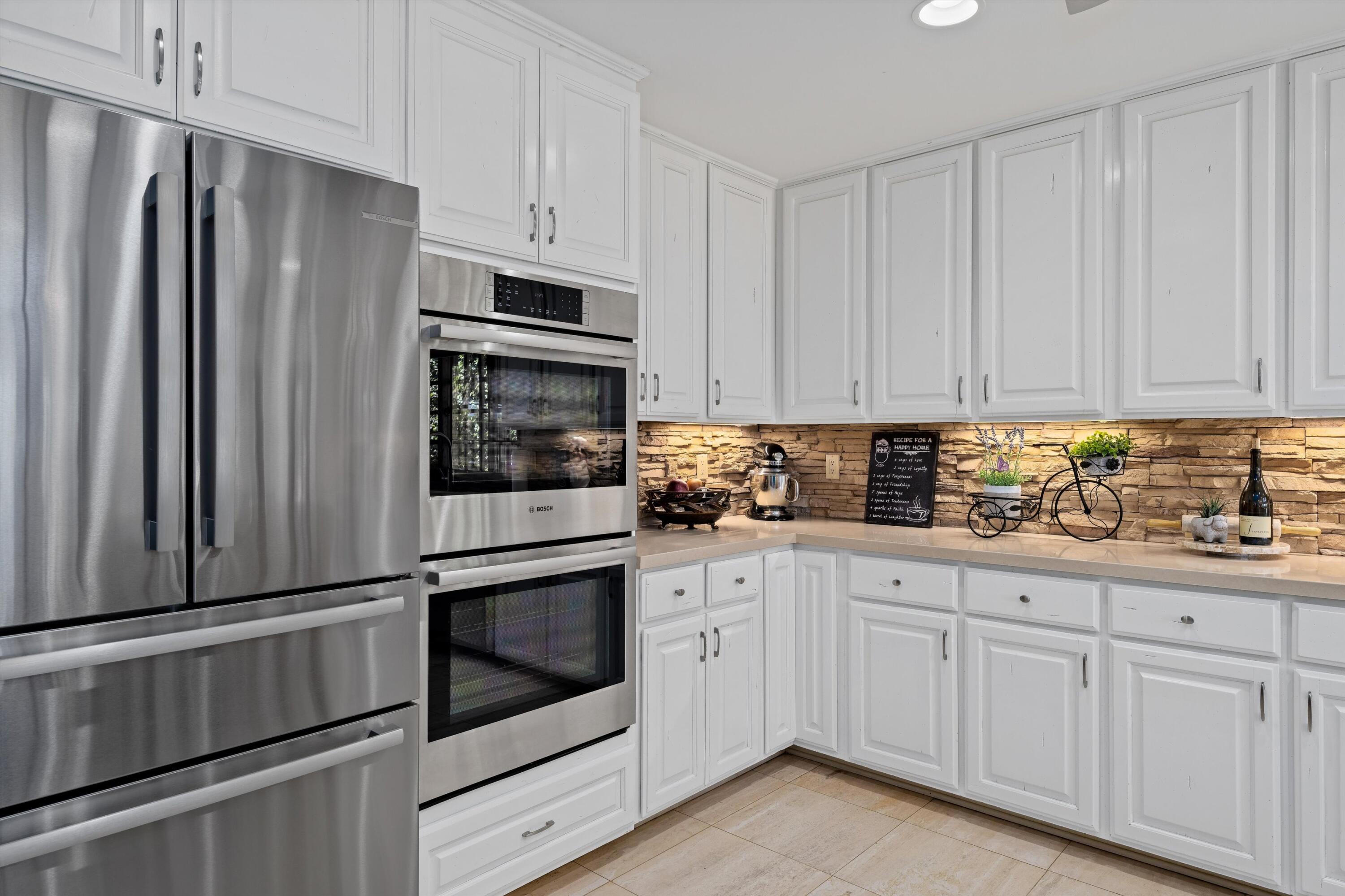 43190 Moore Circle Bermuda Dunes, CA 92203 - Photo 16 of 50 a kitchen with granite countertop white cabinets and stainless steel appliances