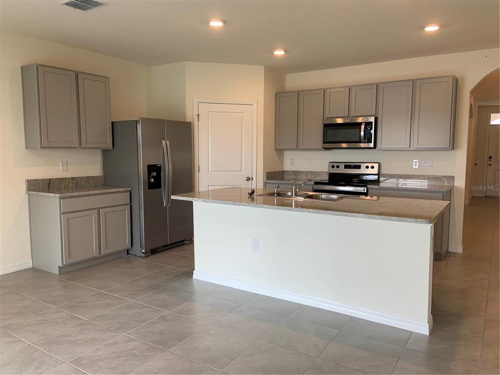 33327 Hamilton Hl Lane Wesley Chapel, FL 33545 - Photo 2 of 11 a kitchen with stainless steel appliances a refrigerator stove microwave and sink