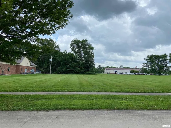 a view of a big house with a big yard and a large trees