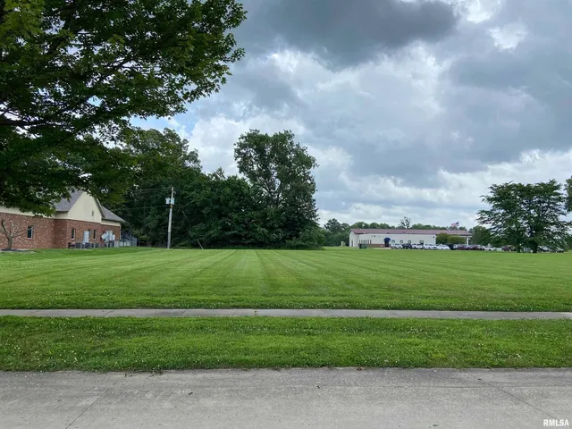 a view of a big house with a big yard and a large trees
