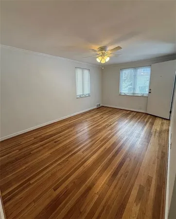 wooden floor in an empty room with a window