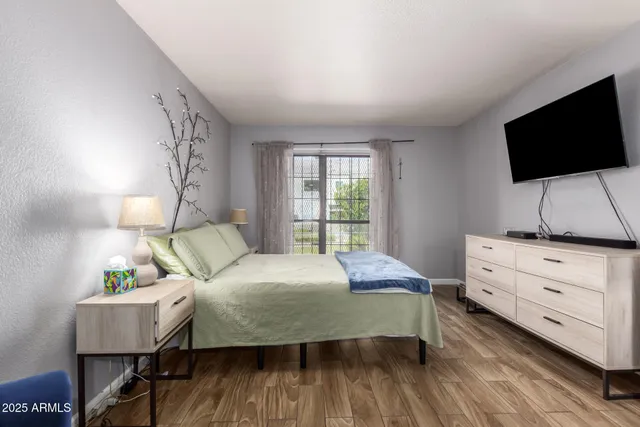 a bedroom with a bed a dresser and chair